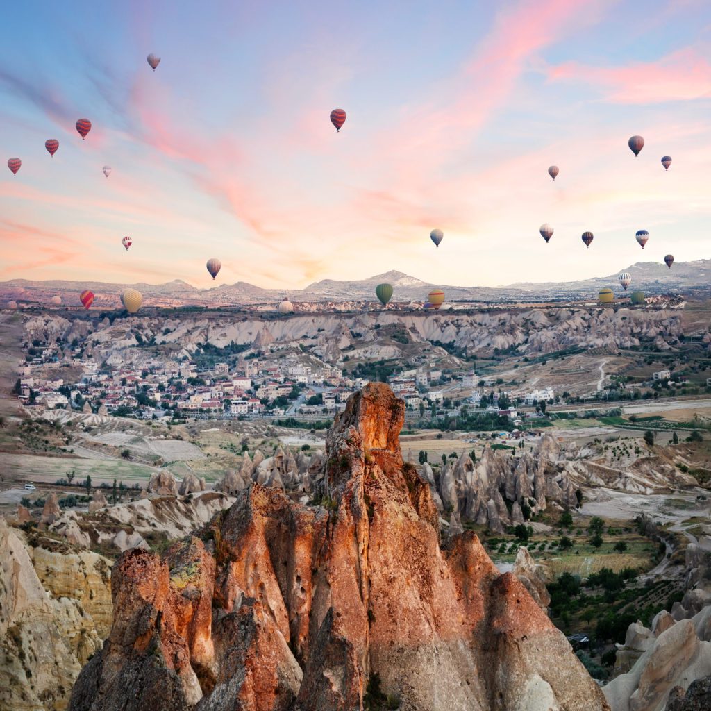 Balloons over rocks of Cappadocia in early morning