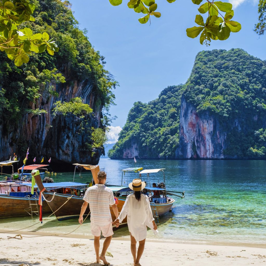Men and women at the Tropical lagoon of Koh Loa Lading Krabi Thailand part of the Koh Hong Islands in Thailand. beautiful beach with limestone cliffs and longtail boats