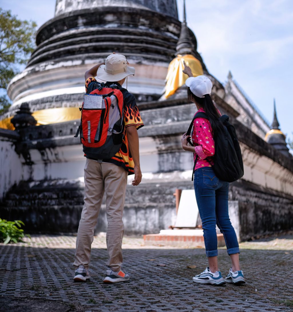 Traveler tourist man and women with backpack walking in historical place temple Ayuttaya Thailand